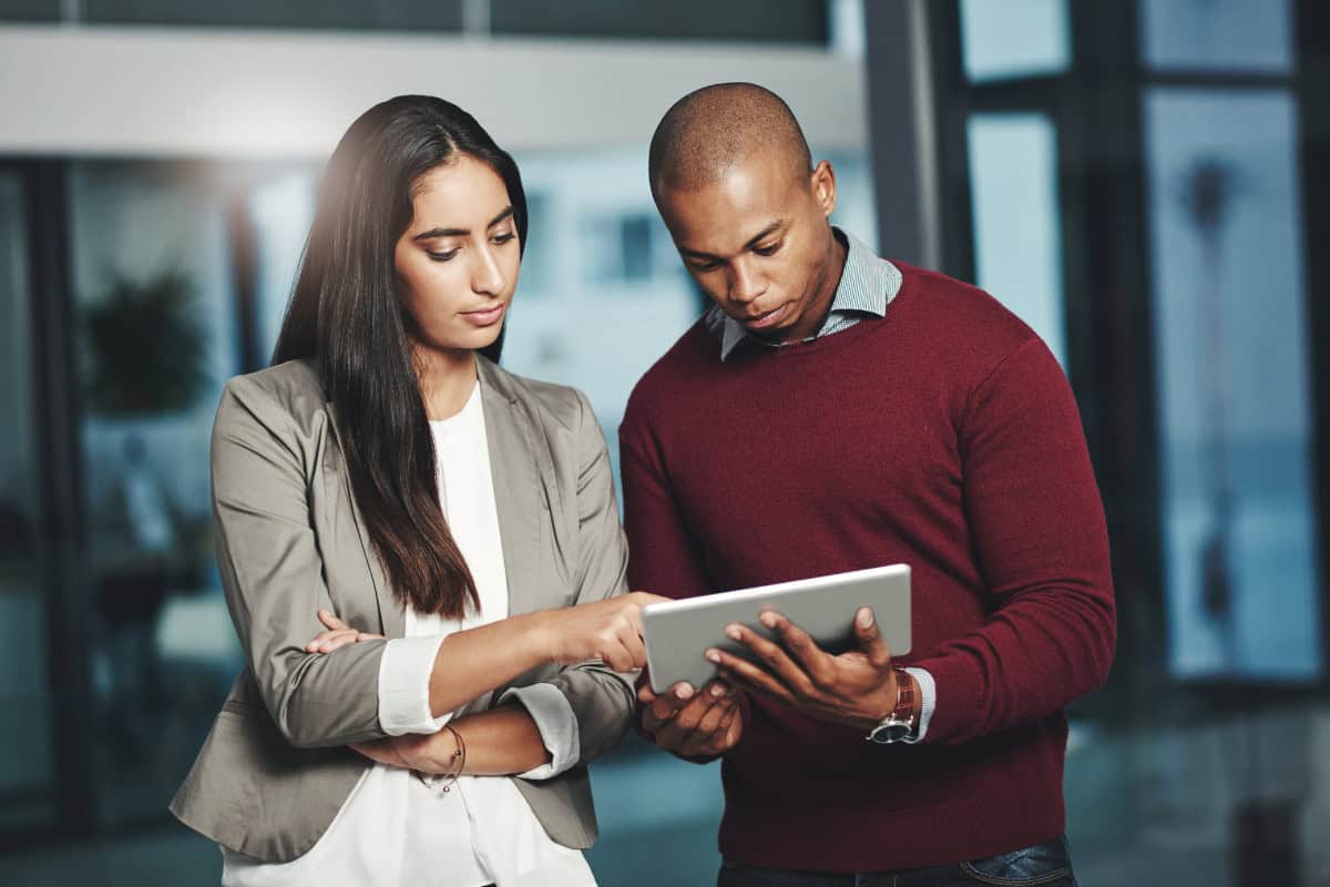 Building Stronger Teams Through Competency Management 2 A man and woman looking at a tablet computer